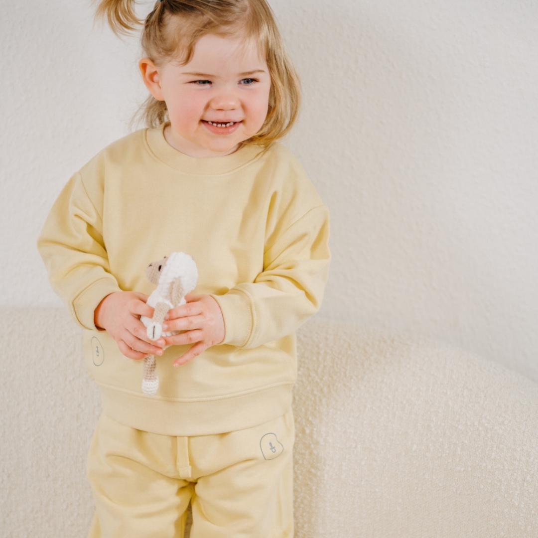 Baby im Wener Christ Bekleidung mit Spielzeug